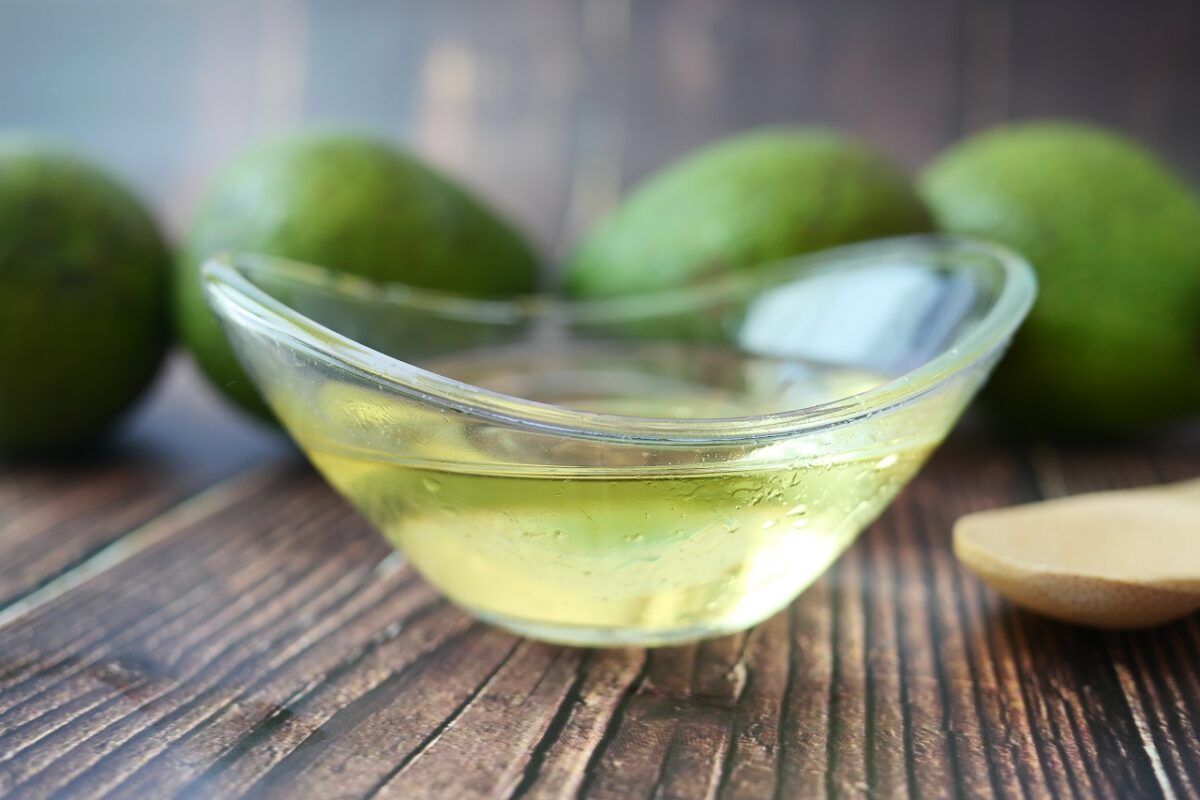 oil and slice of avocado on wooden table
